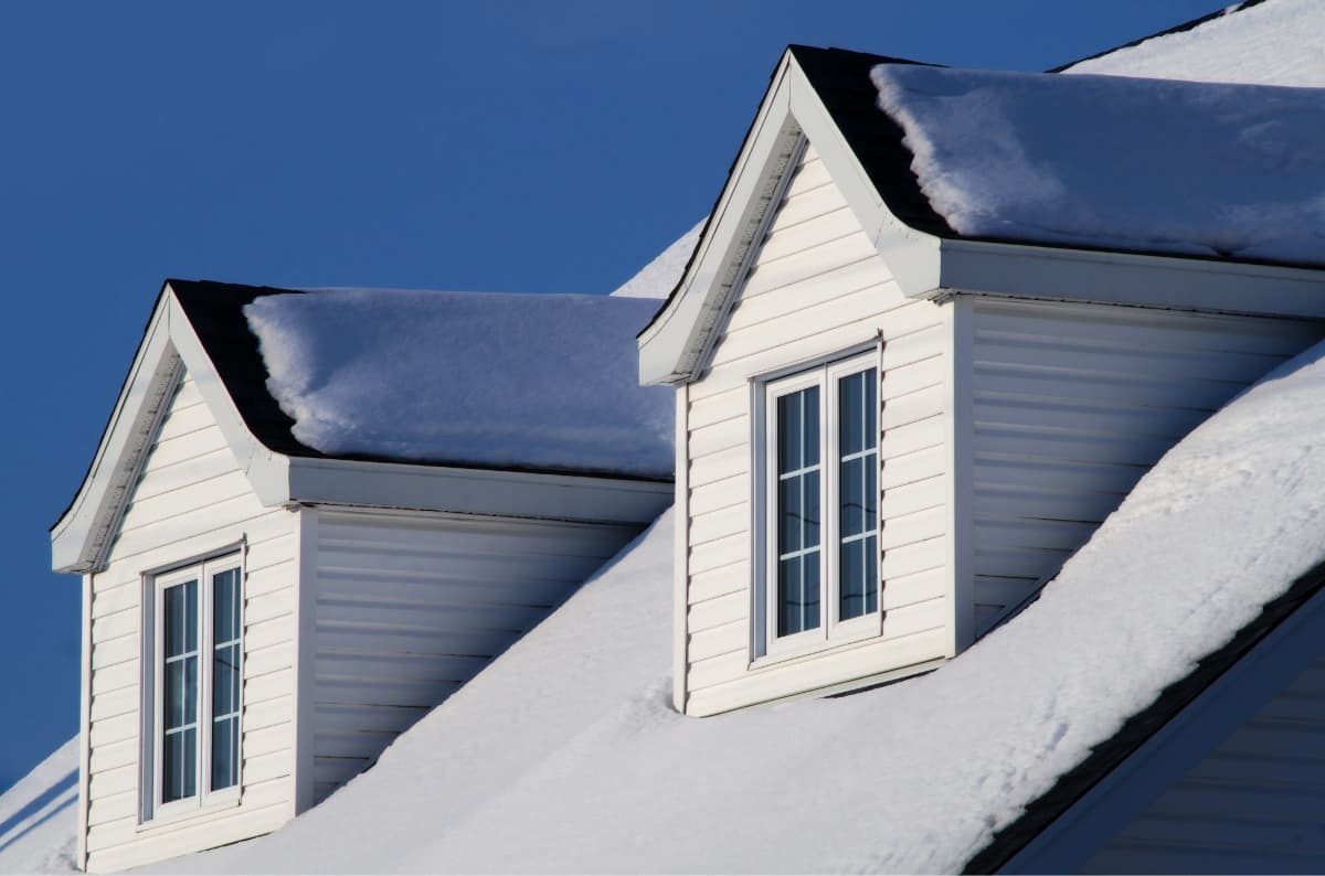 snow on roof with blue sky in background